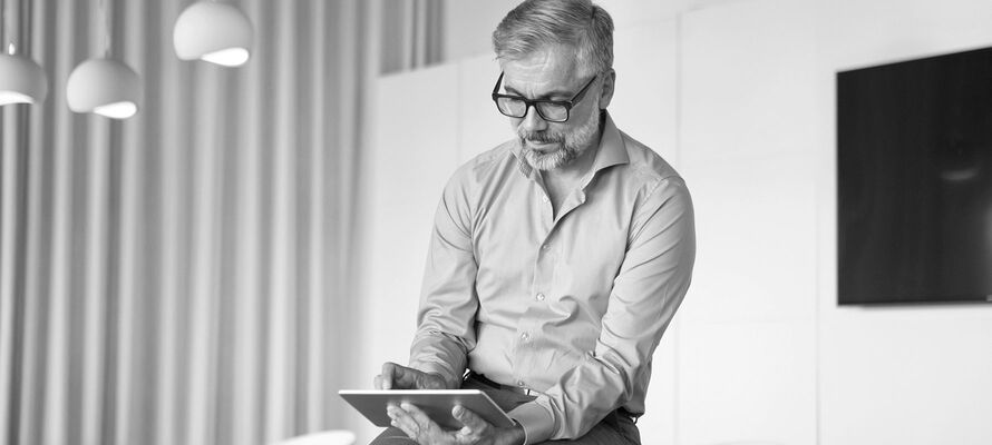 Mann liest, über ihm hängen Leuchten